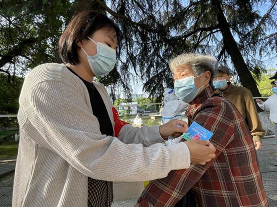 西园新村小区，三里庵街道志愿者正在给完成核酸检测的市民发放温馨小卡片，以感谢群众的积极配合。（仲名山 詹伟伟 孙雨静）