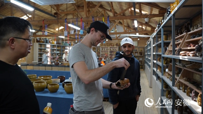 阿什拉夫(右一)和克里斯托夫·盖特纳(右二)观看陶器。人民网记者 王锐摄
